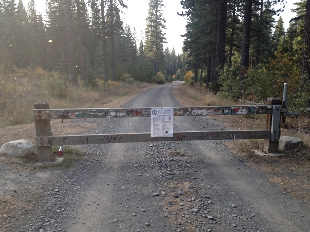 Forest road closed by a gate in Oregon during summer fire restrictions.