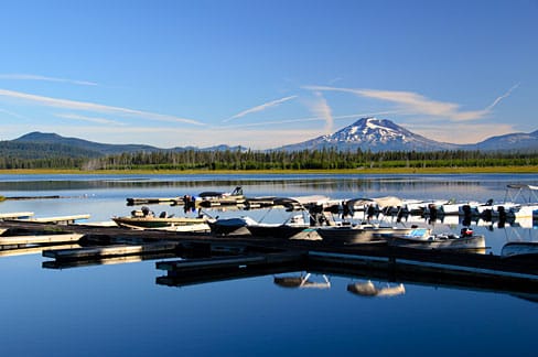 Crane Prairie Reservoir in central Oregon at golden hour, with the campground area visible across the water.