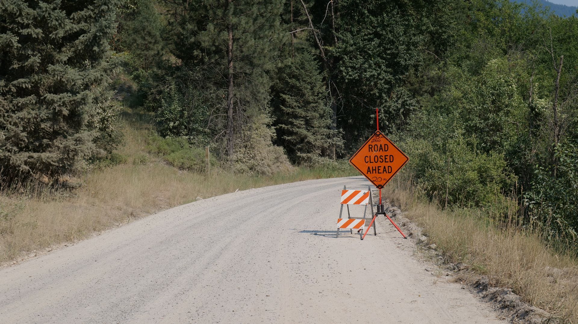 A USFS forest road closure sign, the kind of notice that arrives overnight on a forest road.
