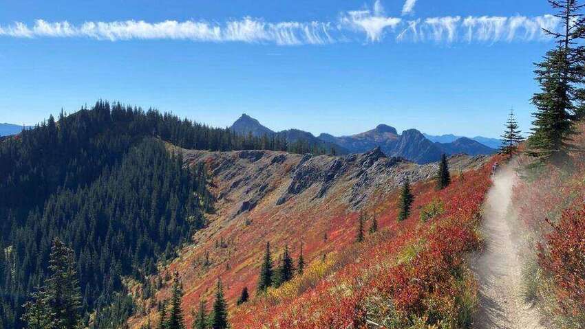 A high-elevation dirt trail along a ridge in the Pacific Northwest Cascades in autumn colors, the kind of terrain where an inReach SOS rescue becomes the only practical extraction.