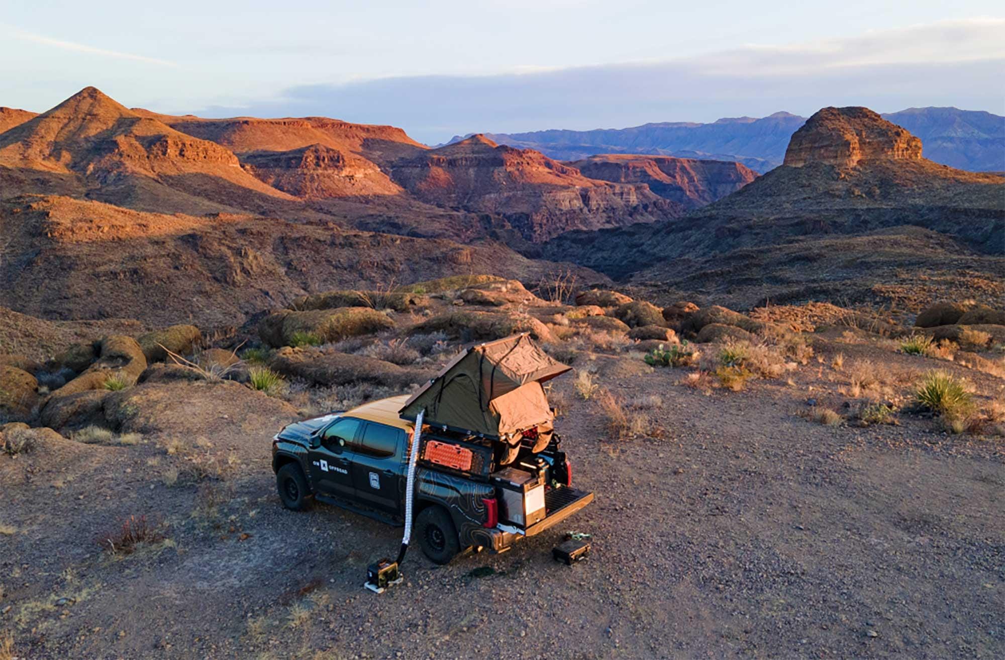 An overland Tacoma truck with rooftop tent deployed at Big Bend Ranch State Park in West Texas at golden hour