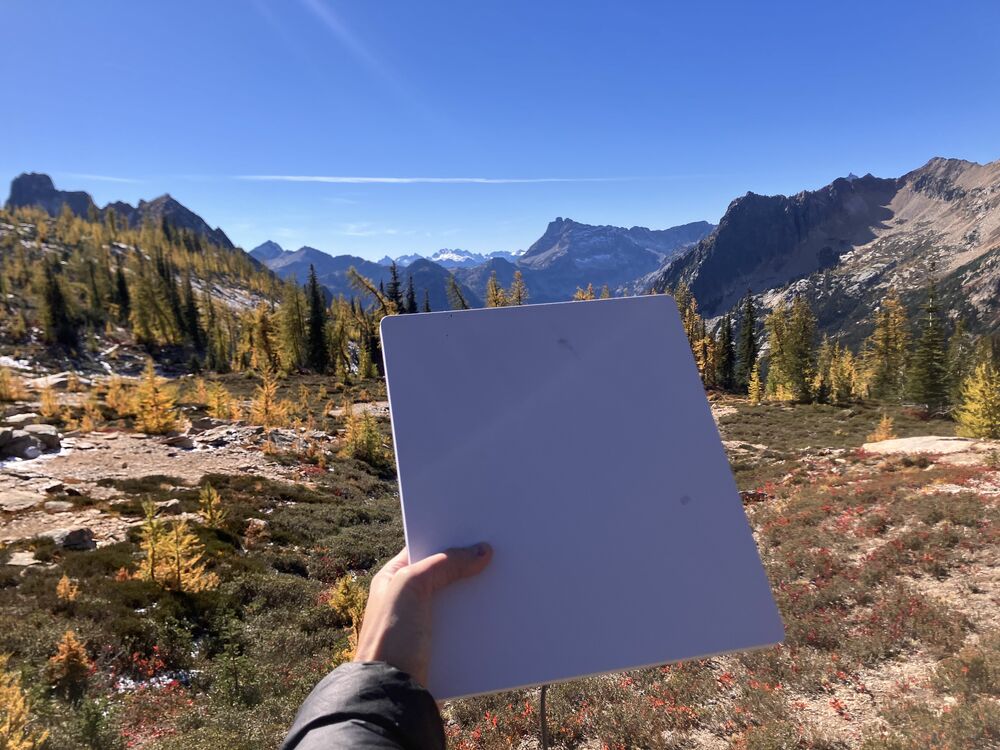 The Mini at a backcountry North Cascades ridge - the laptop-sized dish with sky clear above, the same view a remote cabin or homestead sees for fixed-mount internet.