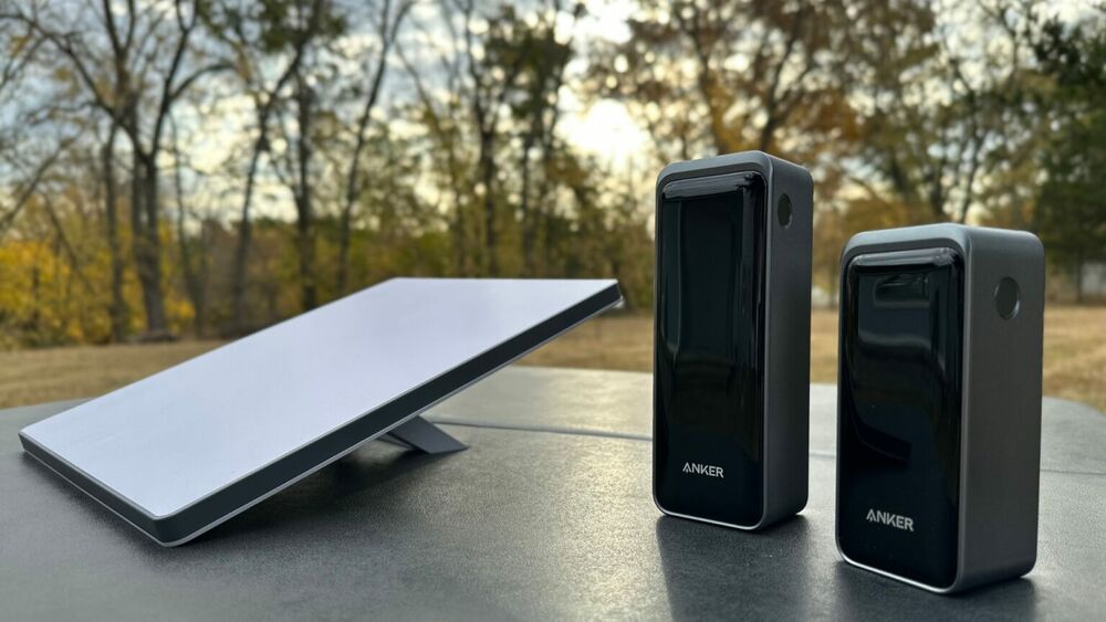 The Mini on a picnic table next to USB-C PD power banks - the family camping setup.