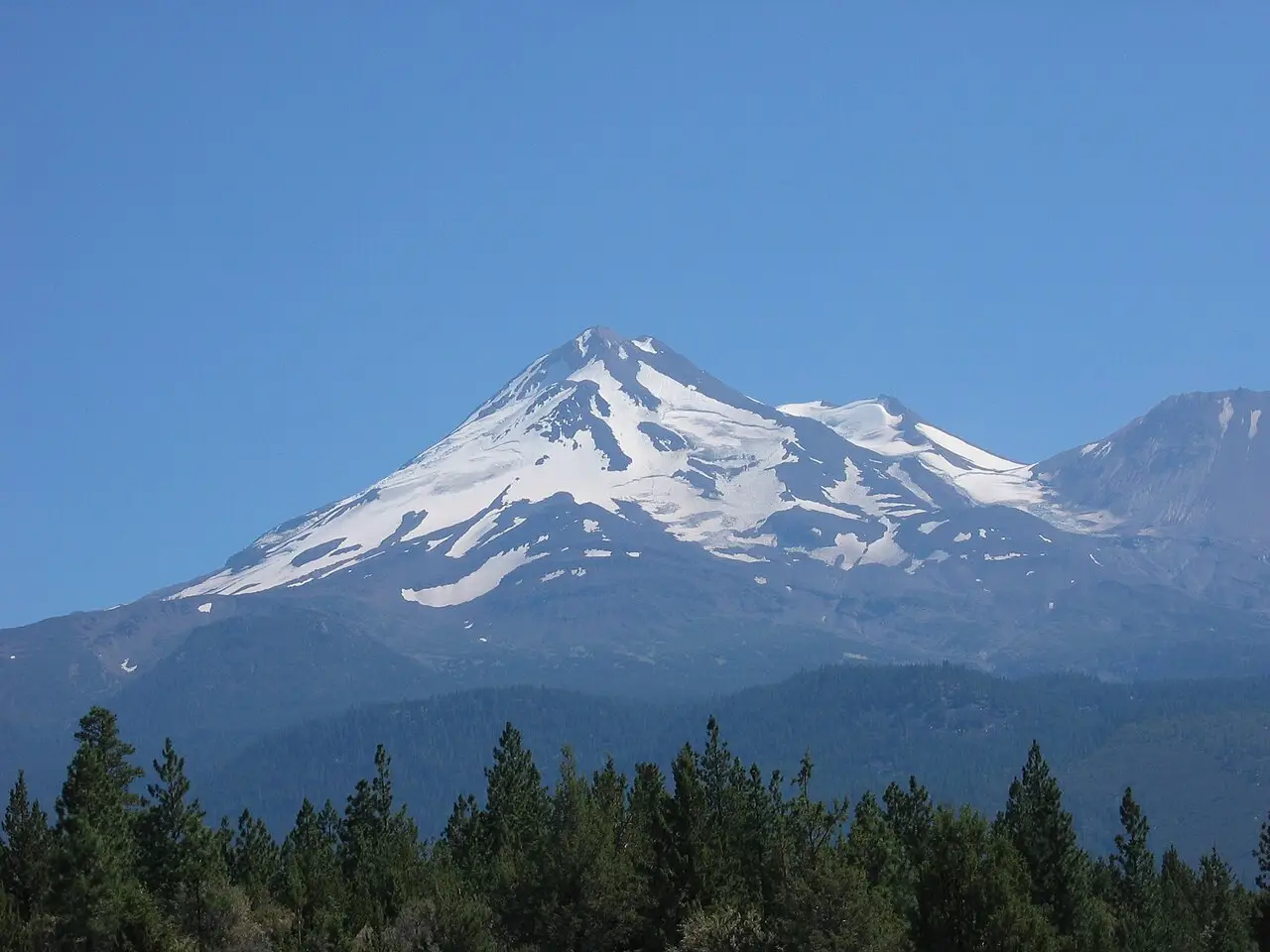 Mount Shasta seen from the south on a clear day, the summit pyramid rising above timberline.