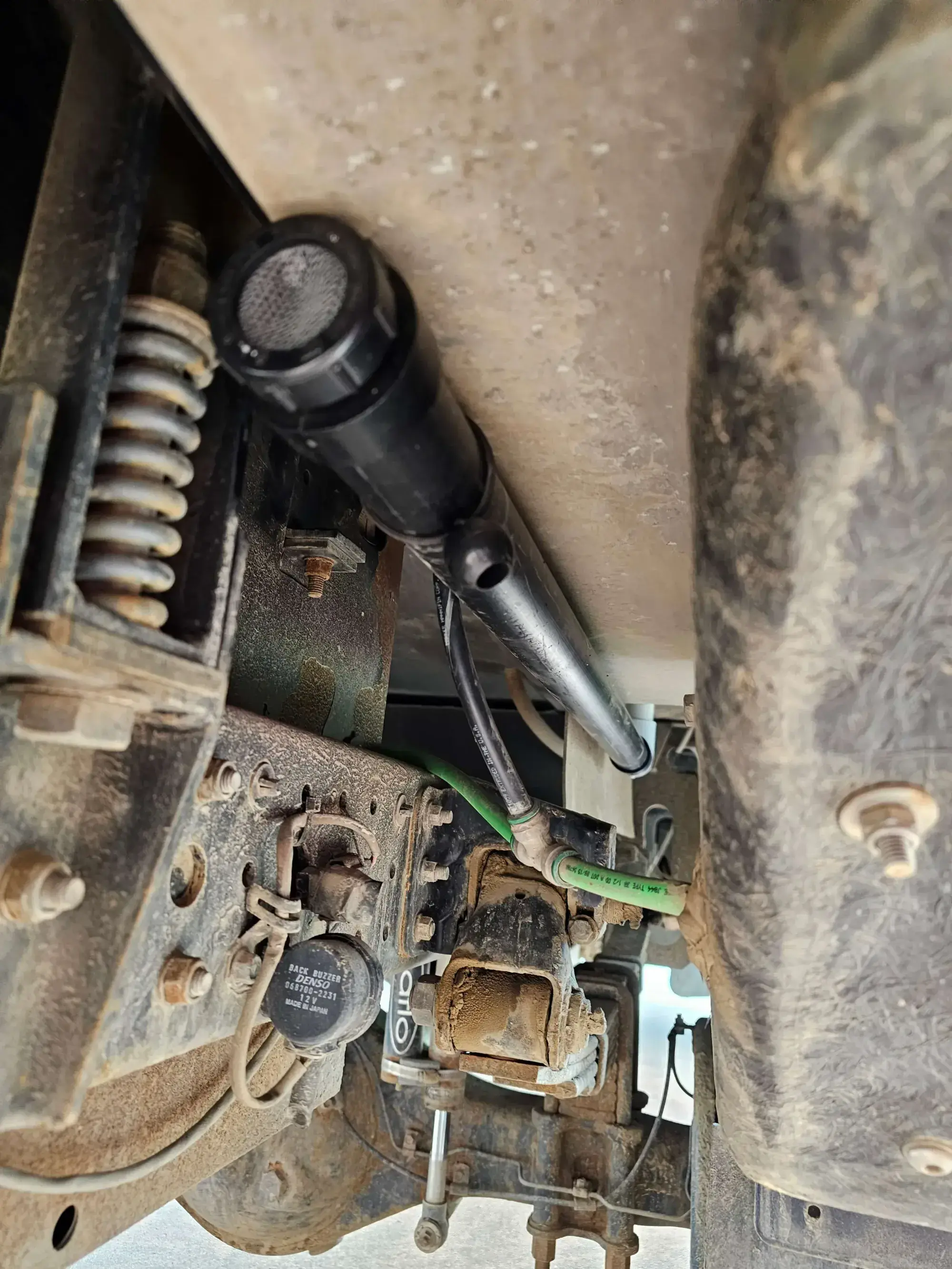 Underside of a vehicle showing the reverse alarm and suspension