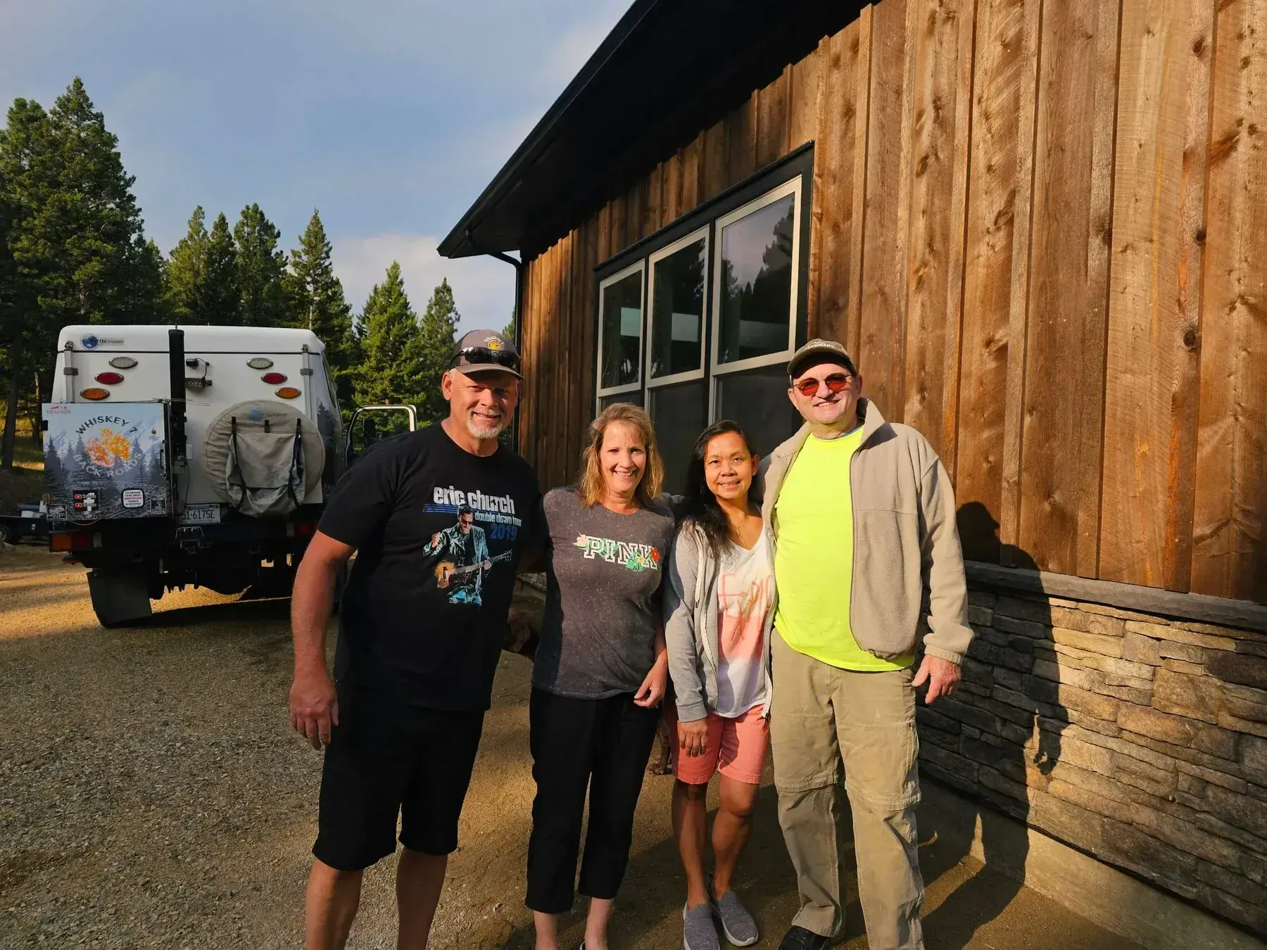 Four adults posing outside a rustic building