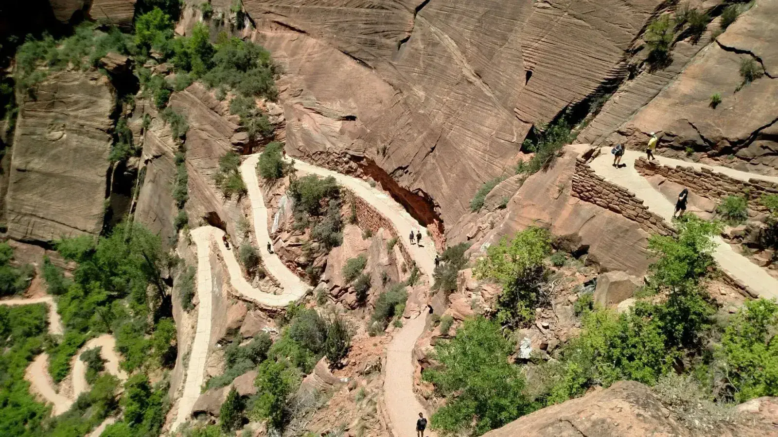 Winding paved trail through red sandstone cliffs
