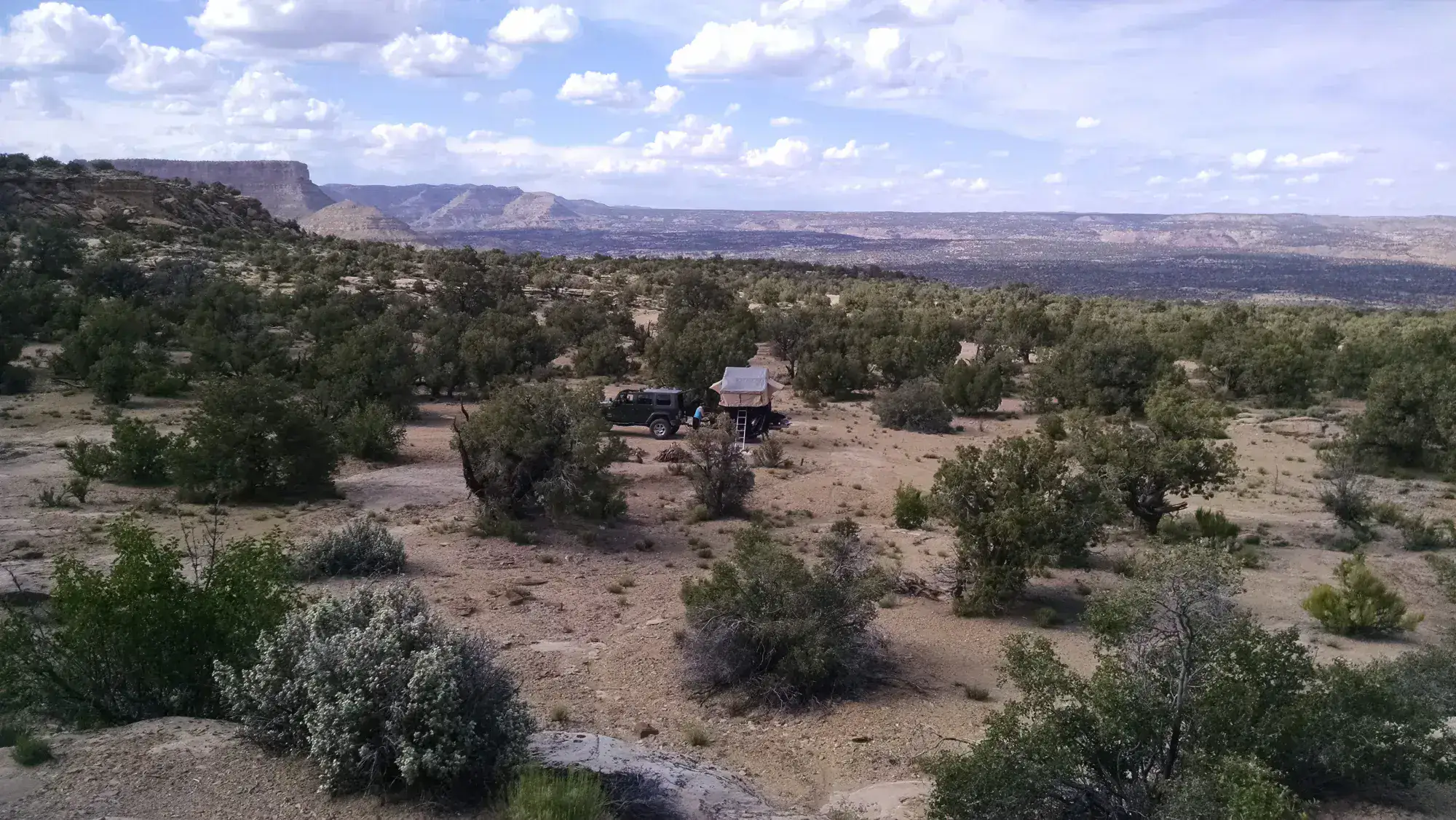 Off-road vehicle and rooftop tent in a desert landscape