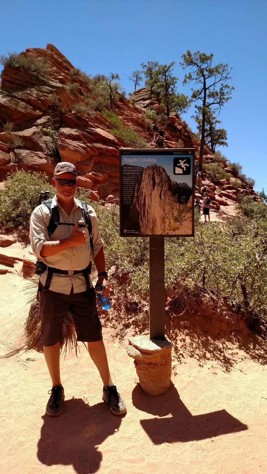 Hiker beside the Angels Landing trail sign