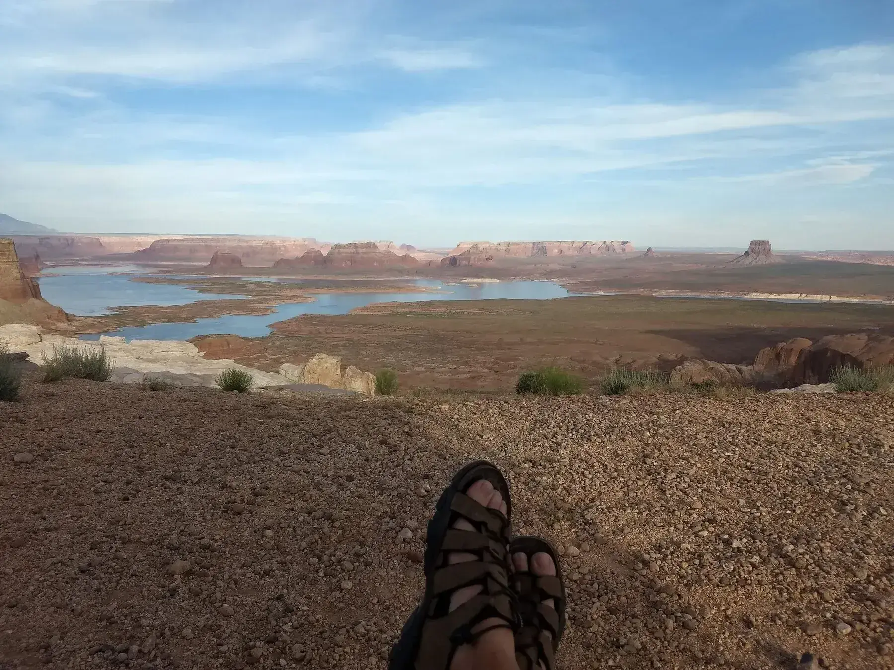 Desert reservoir and red-rock mesas with feet in the foreground