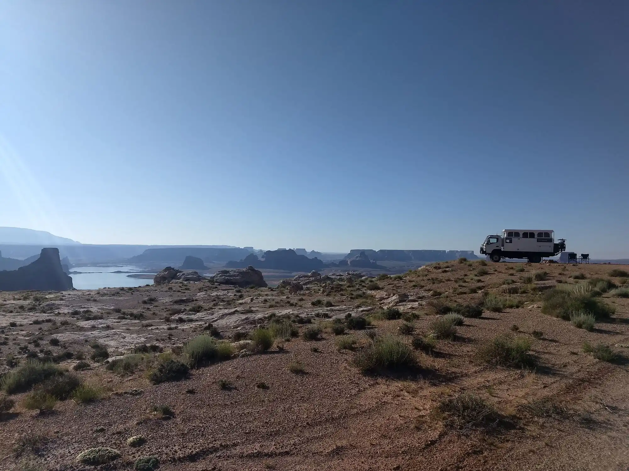 Expedition truck and chairs above a reservoir overlook