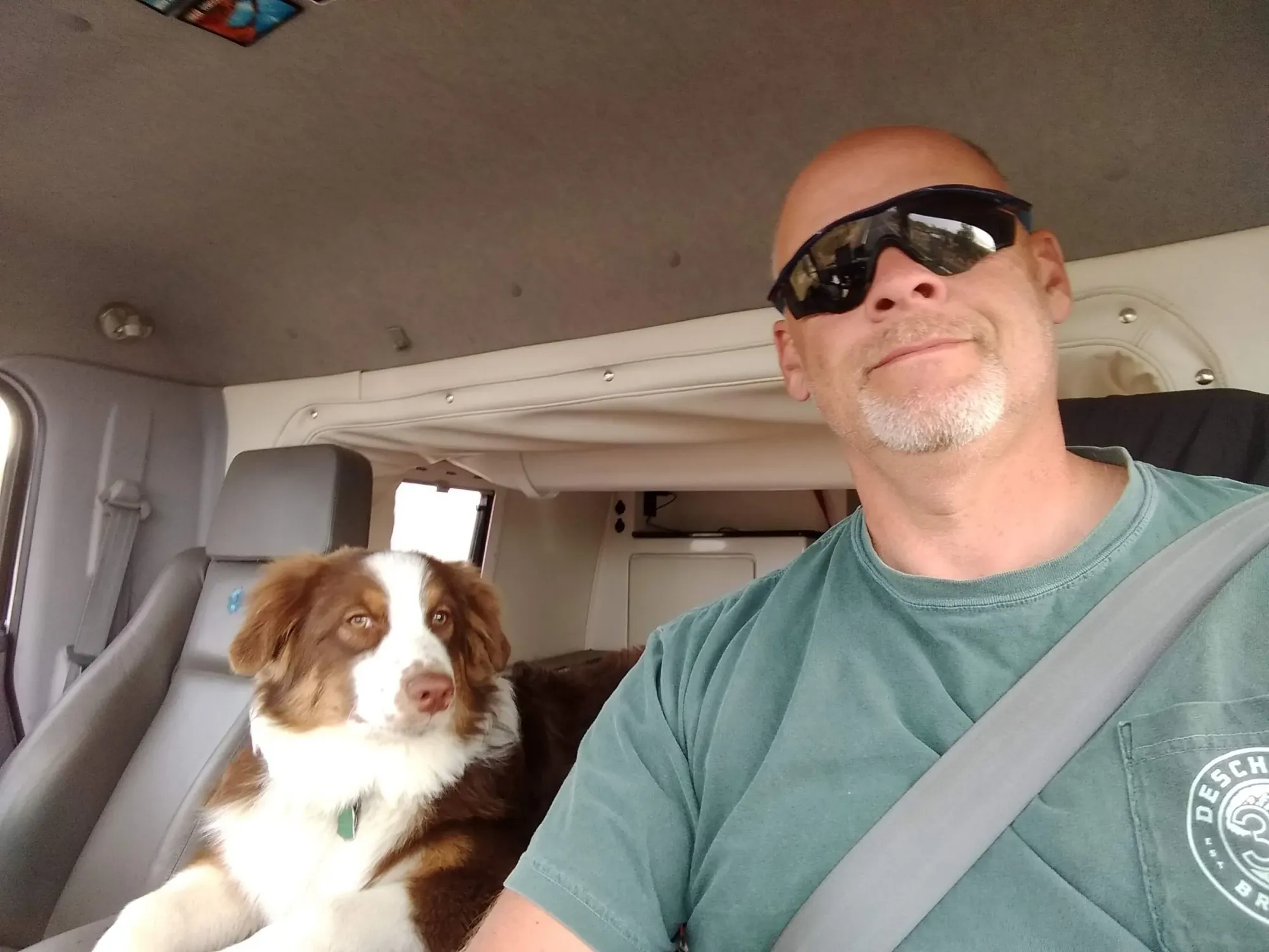 Man and dog sitting in a vehicle
