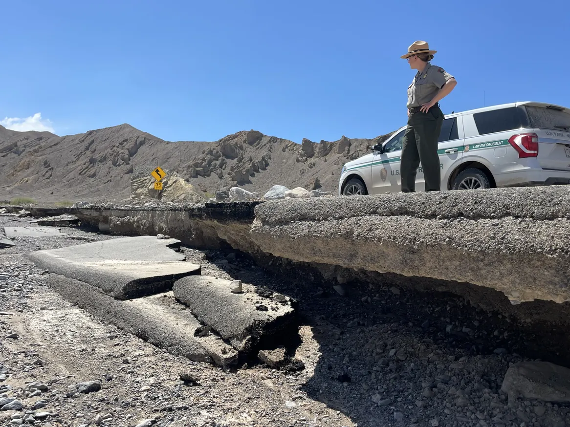 Ranger and park vehicle above collapsed pavement along CA 190 in Death Valley