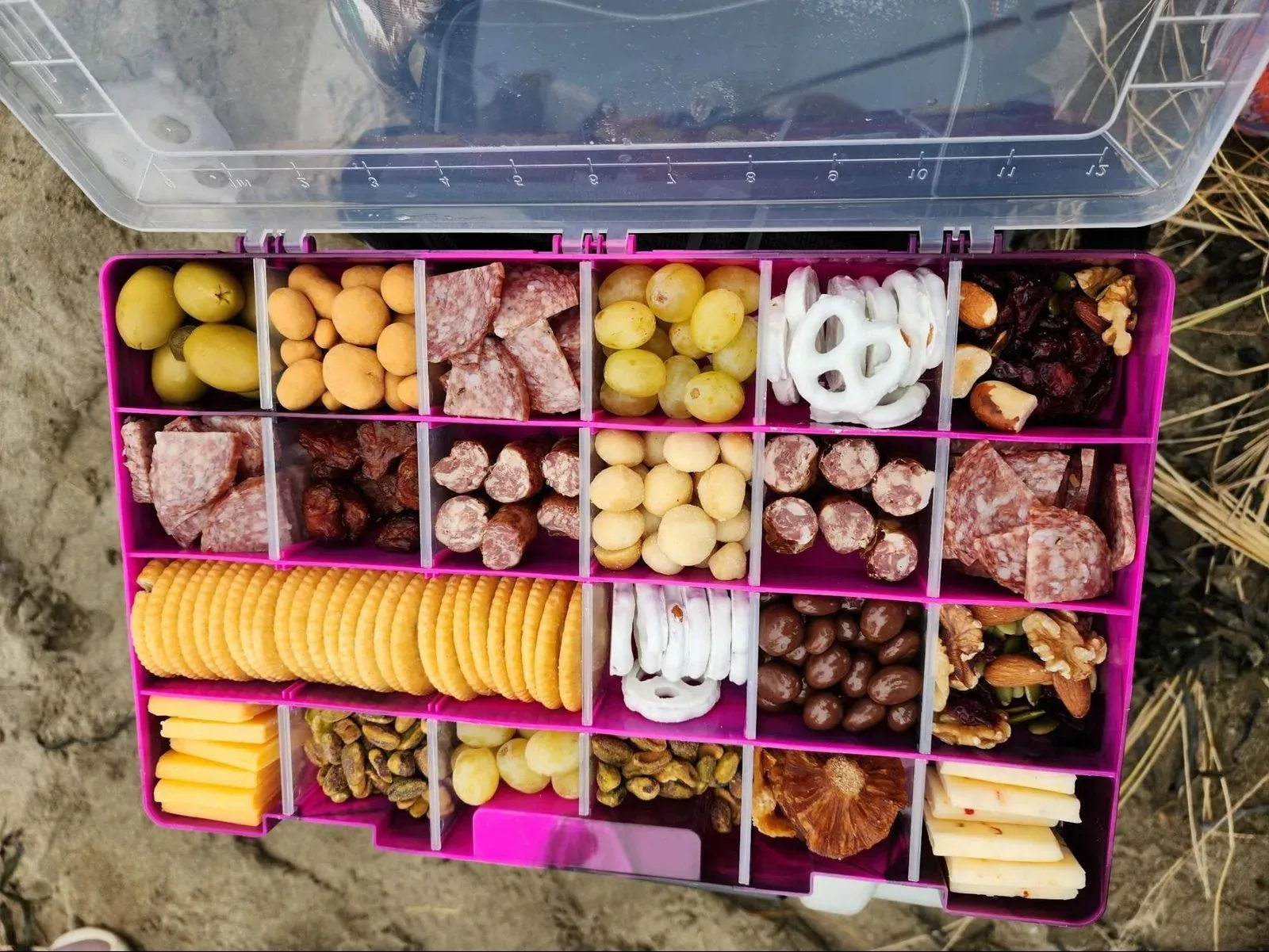 Open organizer filled with picnic snacks and cheeses