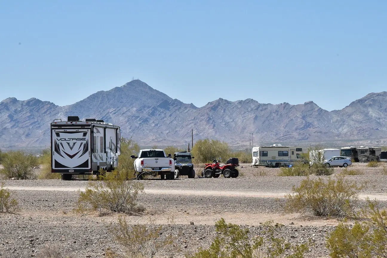 Trailers, motorhomes and trucks camped on open desert at La Posa Long Term Visitor Area, Arizona.