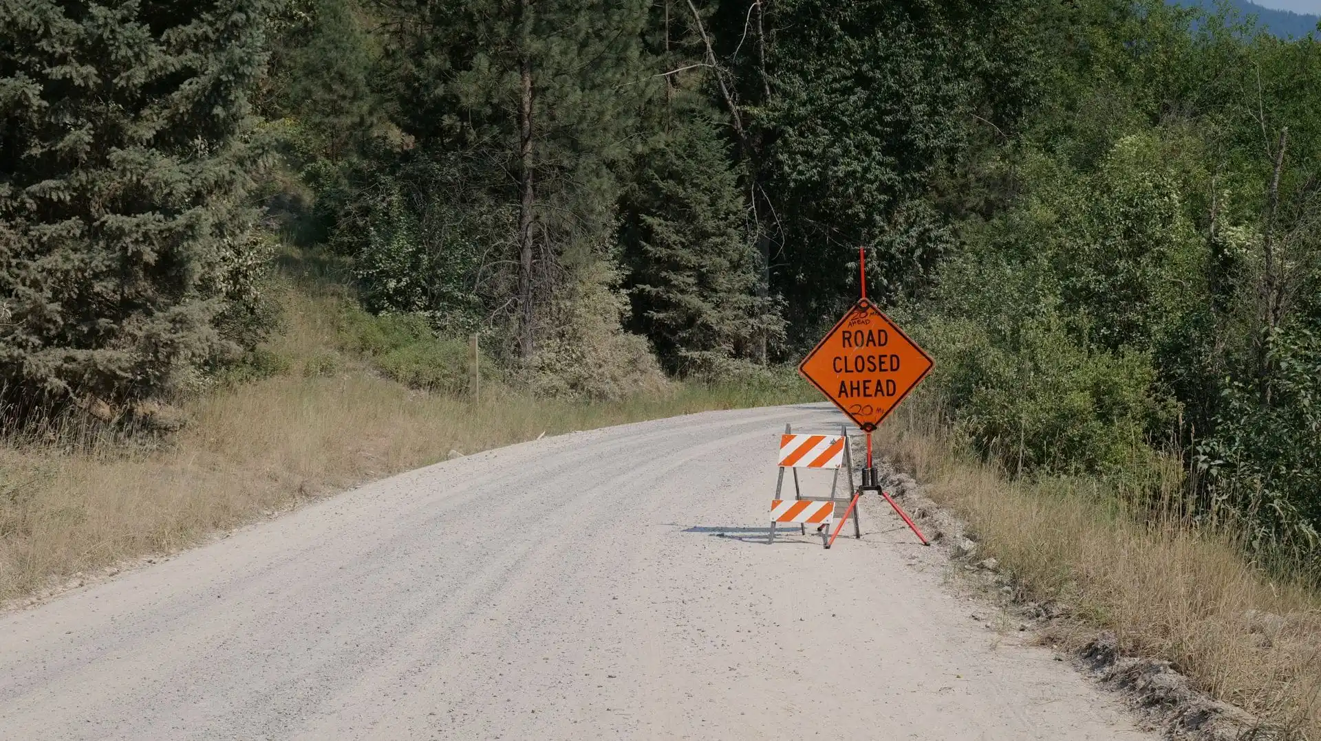 A USFS forest road closure sign, the kind of notice that arrives overnight on a forest road.